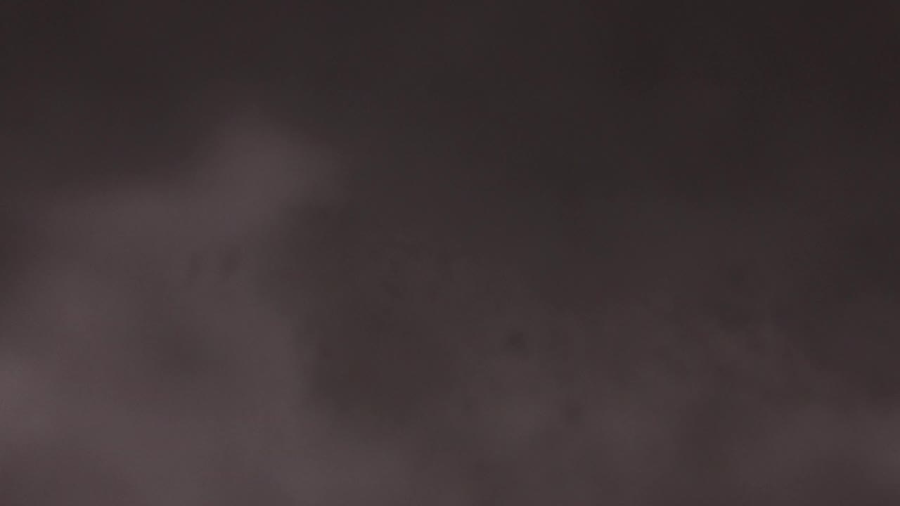 Muted cloud shapes spread across a brown night sky in Jefferson, Colorado, with soft light variation near the upper center and no visible people.