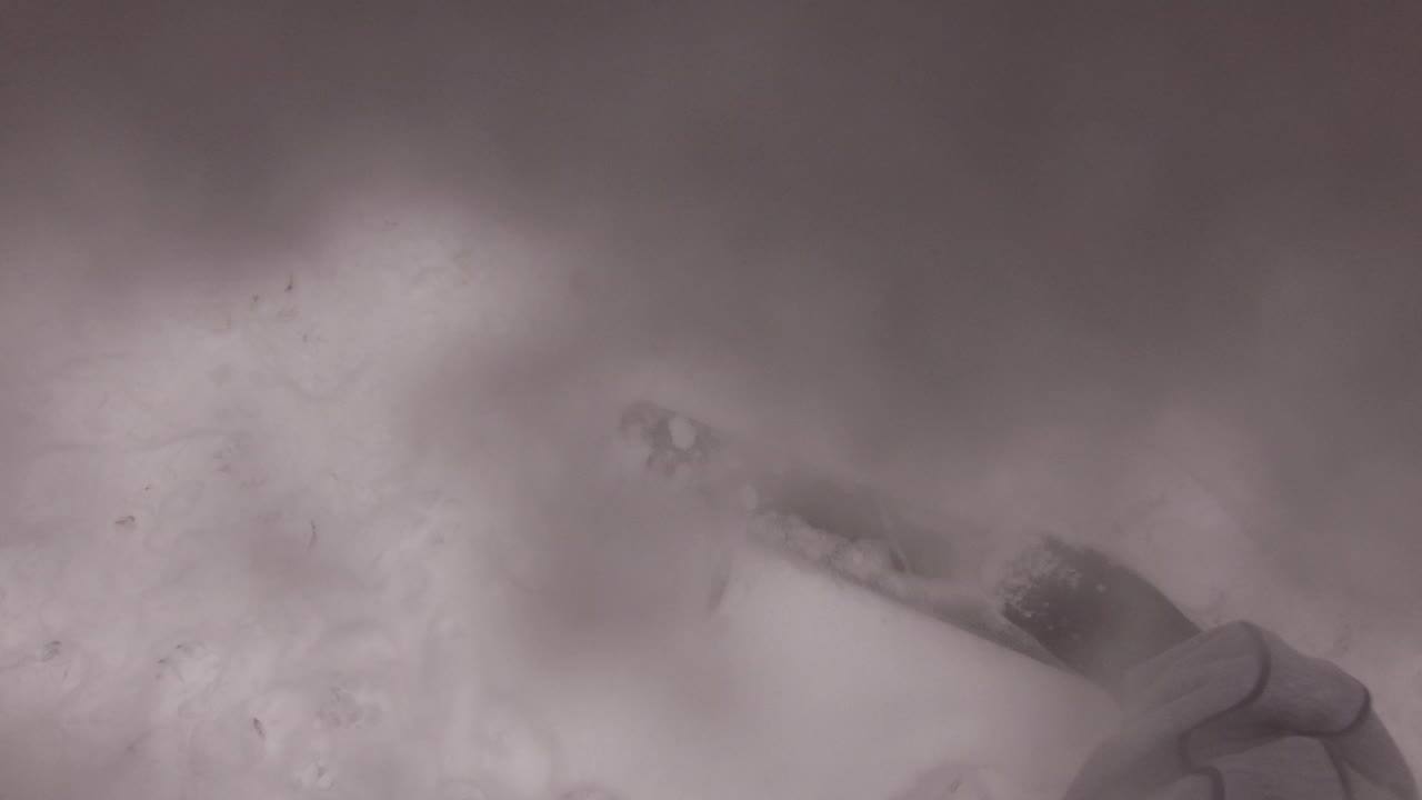 Blurry boot stepping into snow from a downward angle.