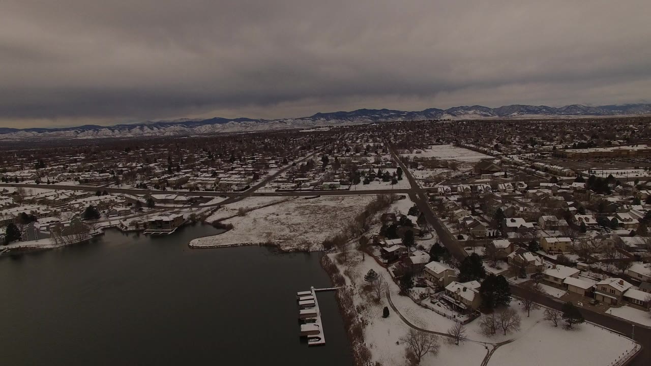 Snowy lakefront neighborhood under gray clouds