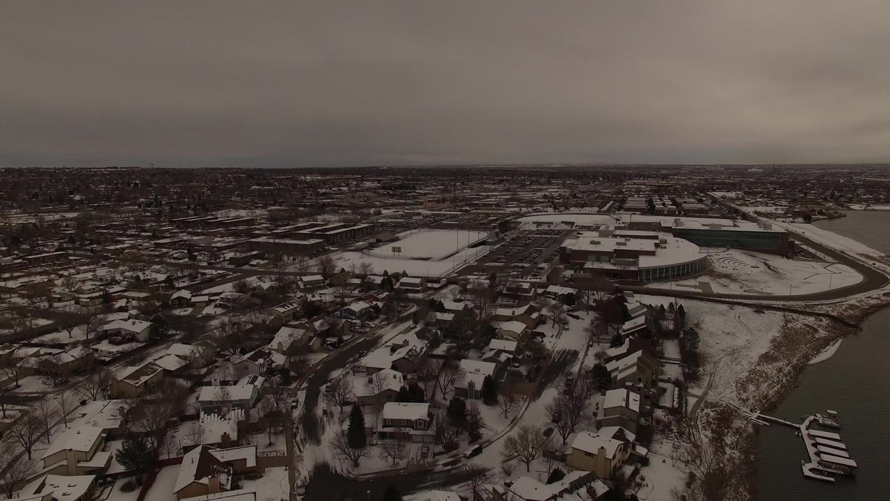 Snowy suburban blocks with a lake edge and docks seen from above.