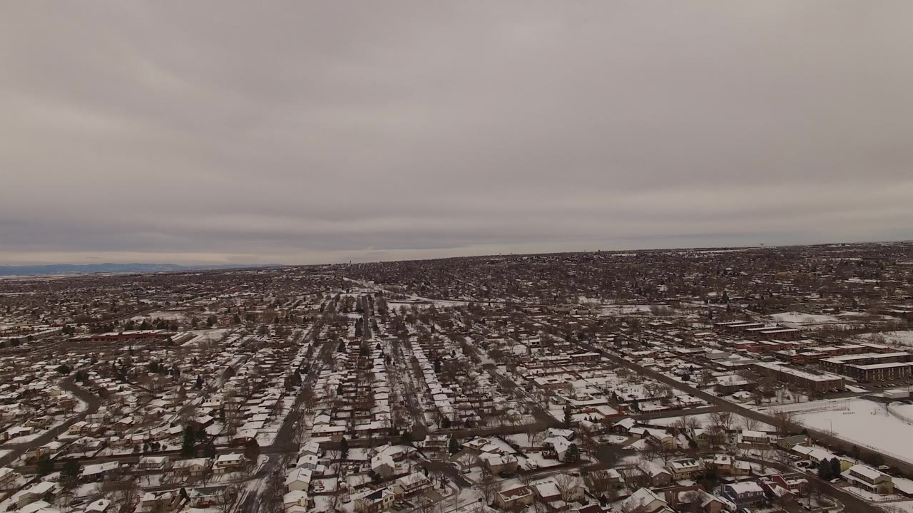 Aerial winter view of homes, roads, and a large rectangular building area.