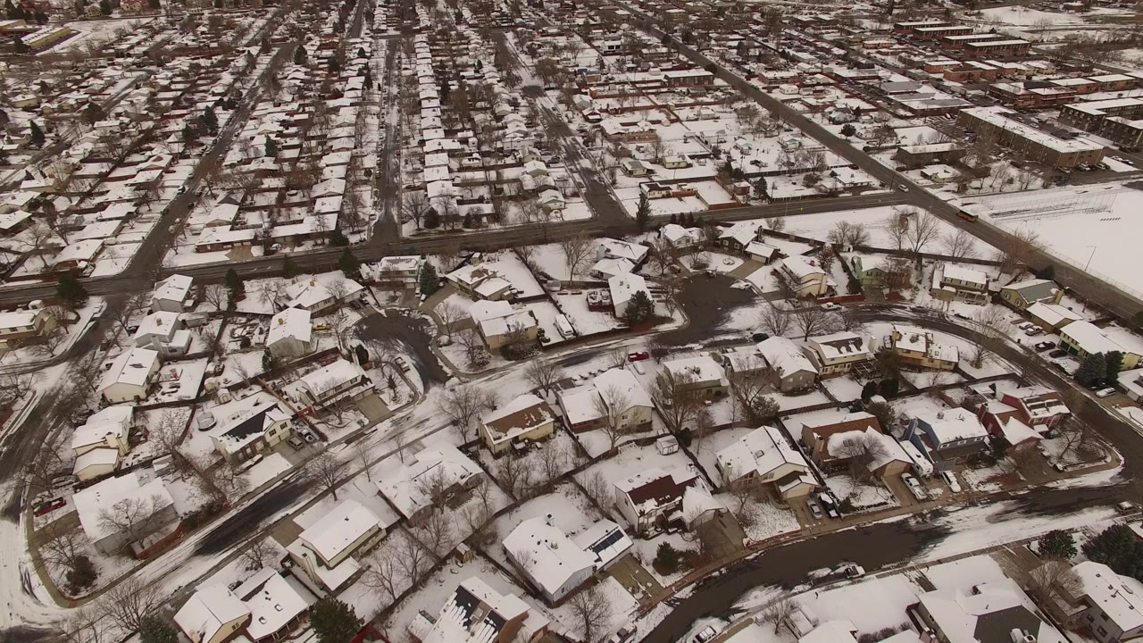 High-angle view of winter homes beside a larger road.