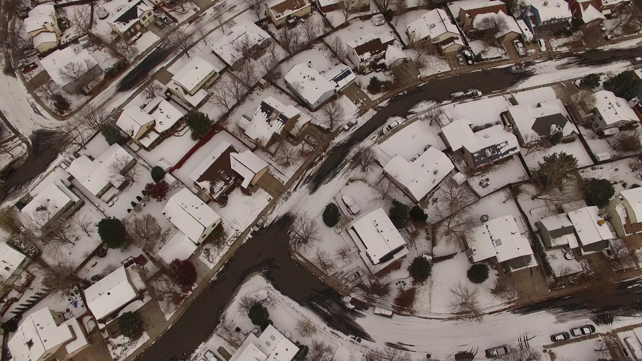 Overhead snowy residential streets and houses.