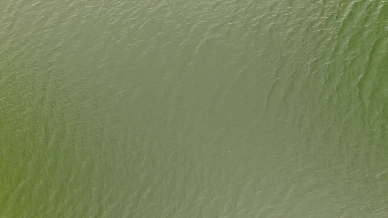 Muted green water in Jefferson County, Colorado, with shallow wave lines crossing the surface and no visible people.