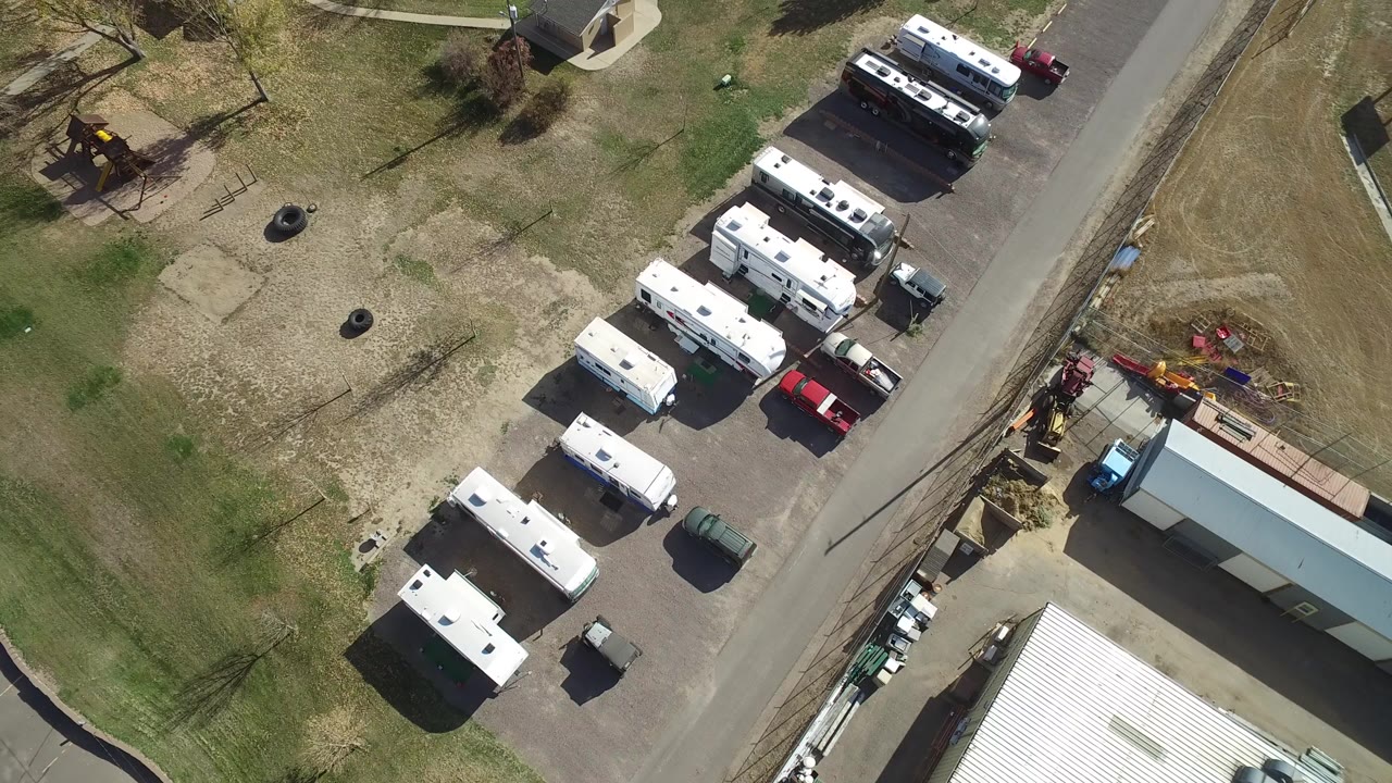 Overhead view of parked trailers beside a road and grassy field.