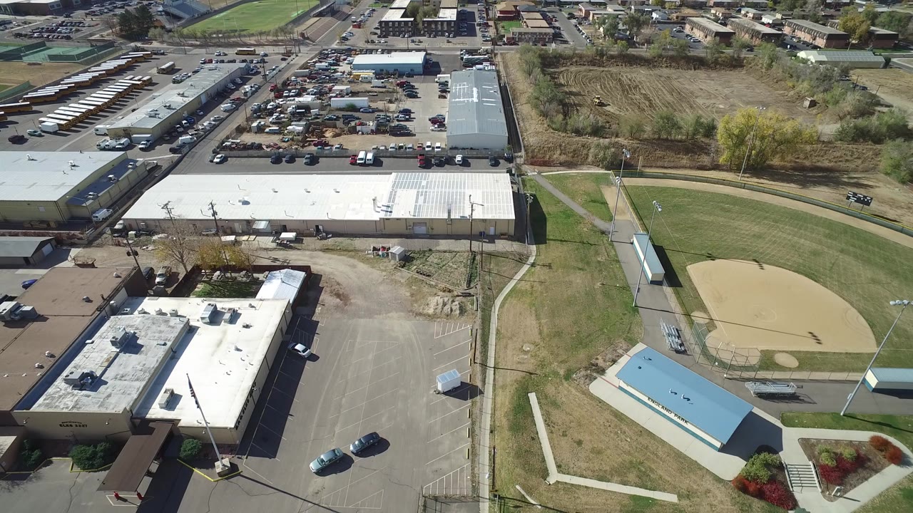 Aerial view of warehouses, parking lots, and a baseball field.
