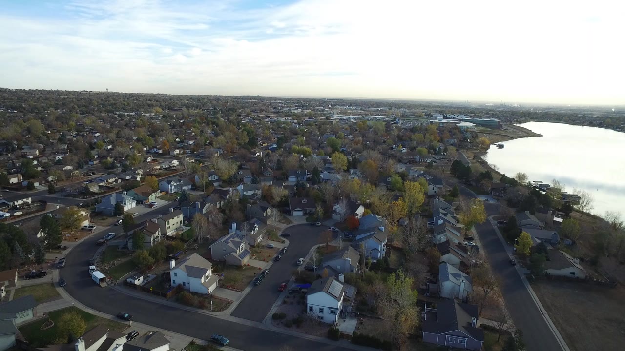 Aerial view of lakeside homes and streets beside a broad lake.