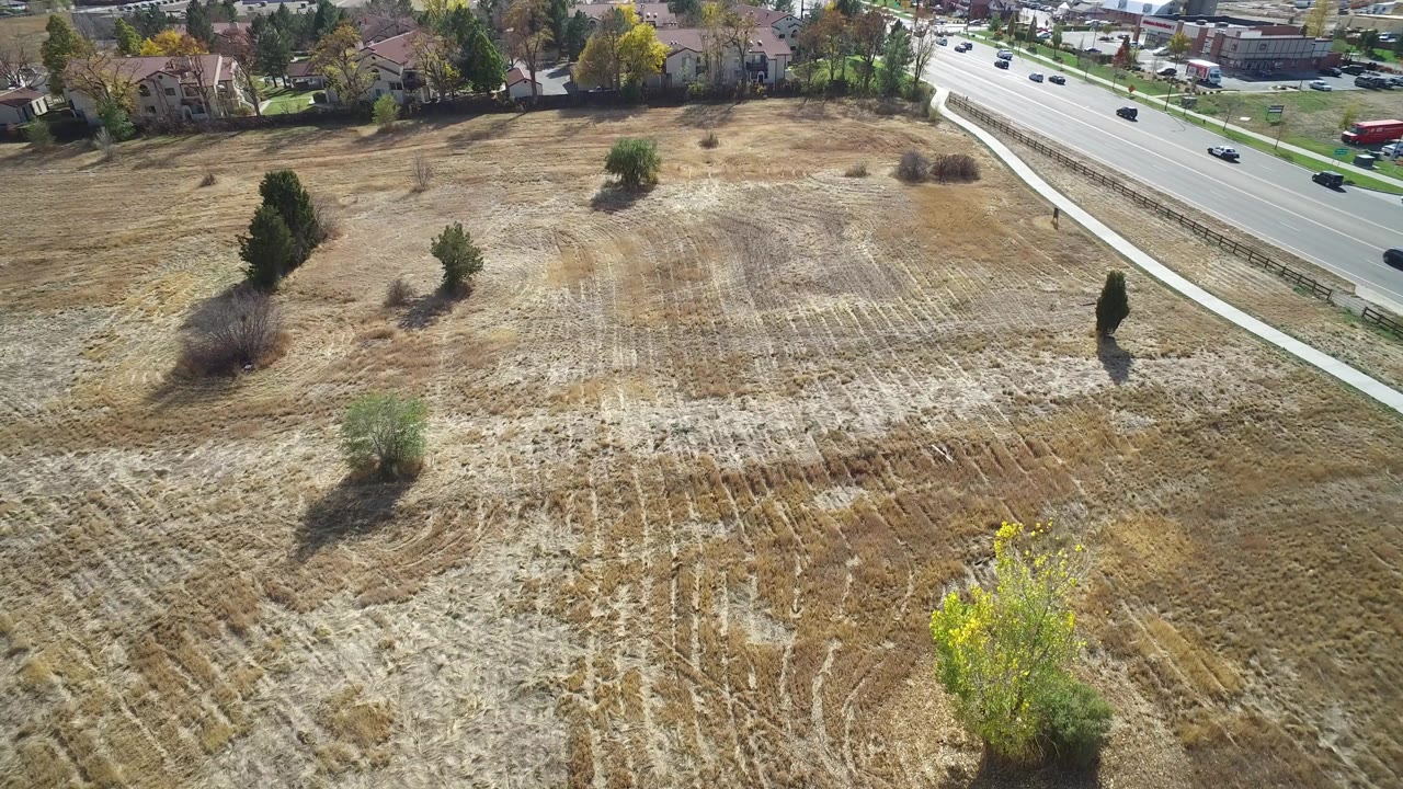 Aerial view of a dry field beside a multi-lane road.