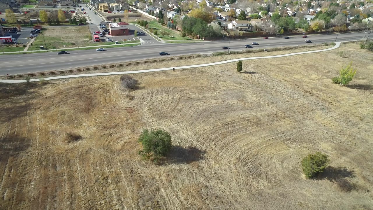 Dry park field below highway and residential area