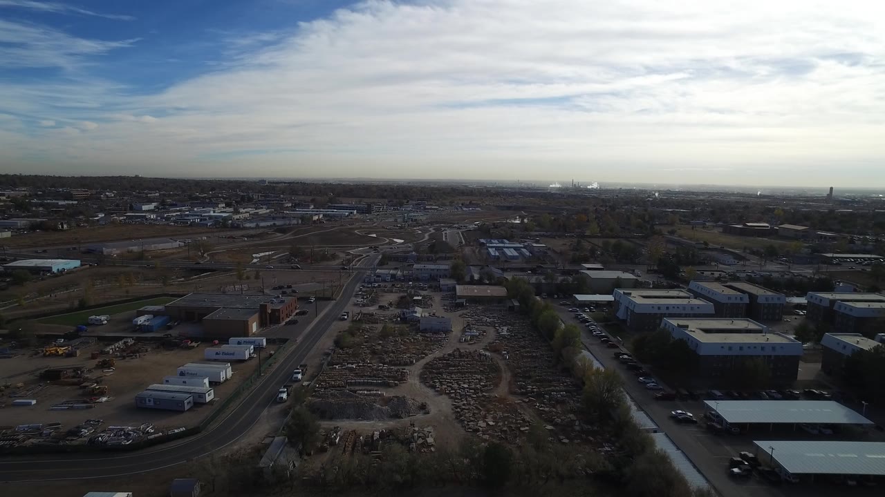 High aerial view across industrial buildings and suburban development.