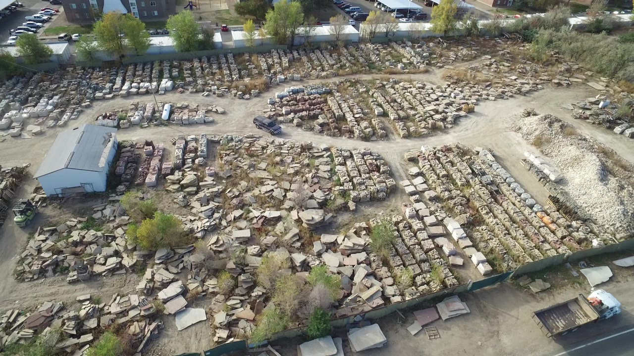 Aerial view of an outdoor materials yard with stacked stone and gravel piles.