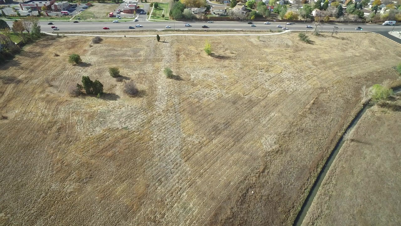 Aerial view of dry field beside a busy road