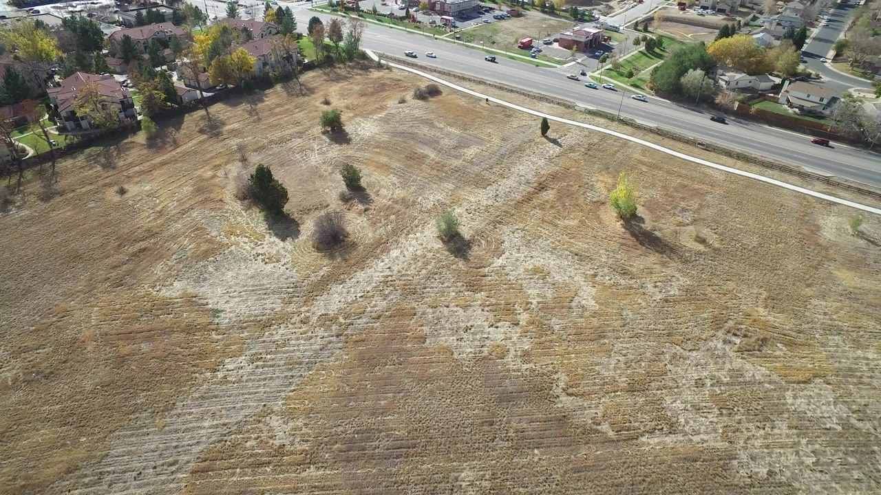 Aerial view of a dry empty lot beside a suburban road