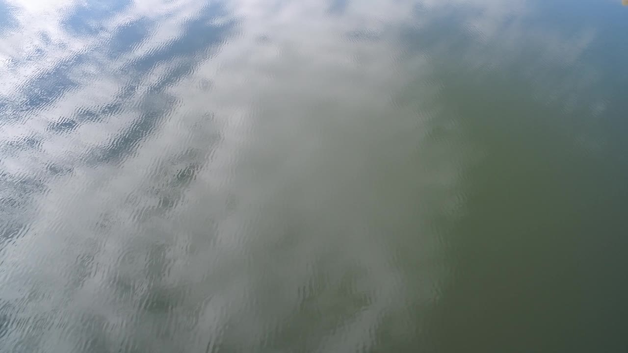 At Hidden Lake, Colorado, rippled green-blue water reflects soft white clouds near the start of the clip, with no visible people.