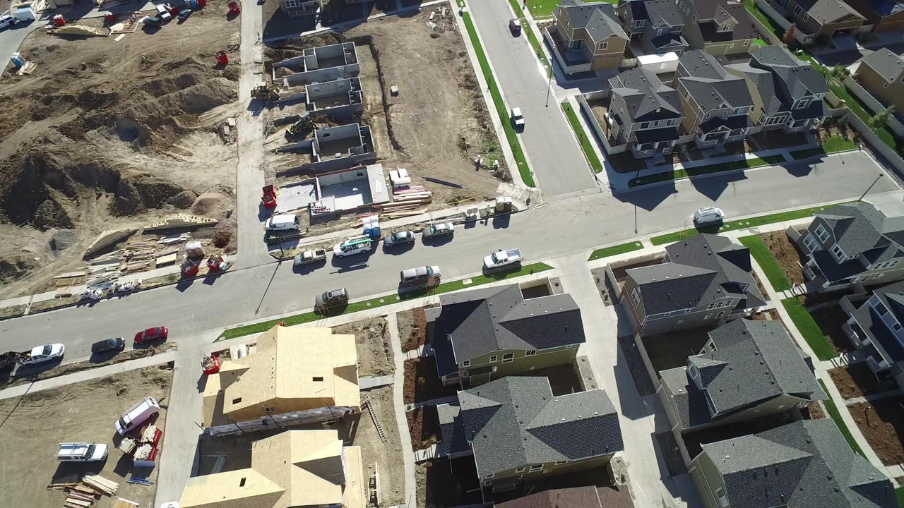 Overhead view of neighborhood roads, homes, and active residential construction.