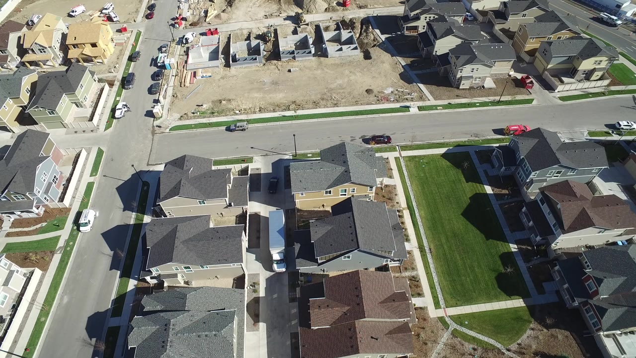 High overhead view of houses, paved streets, green lawns, and exposed construction lots in Hidden Lake, Colorado, with no visible people.