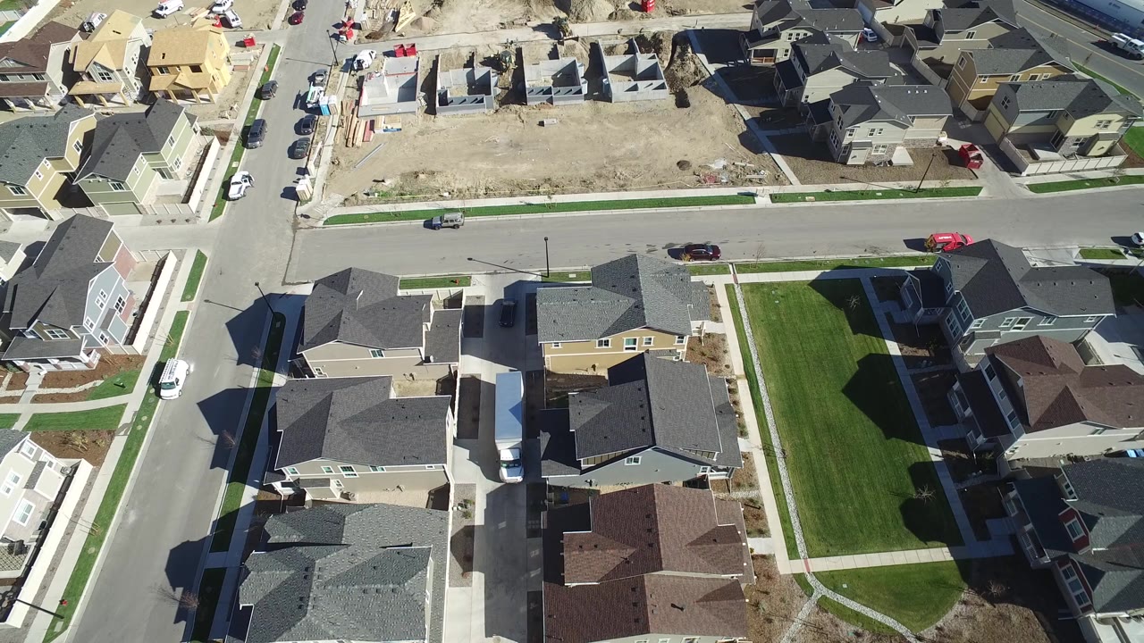 Aerial view of residential blocks with green lawns and construction ground.