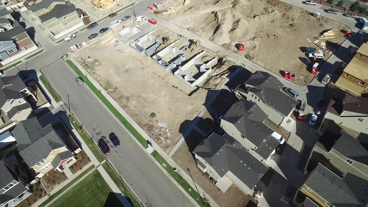 Aerial view of suburban houses beside a dirt construction lot