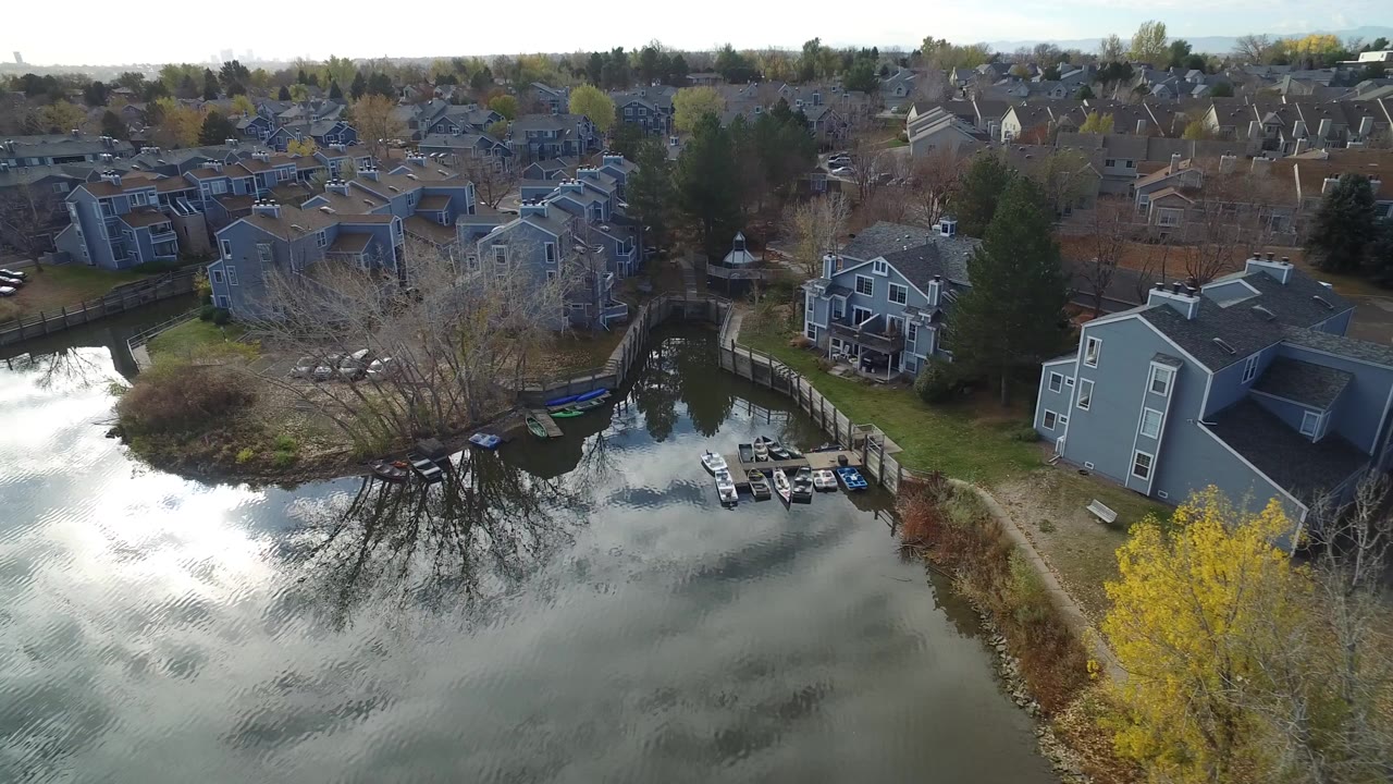 Aerial view of grey lakefront houses, docks, and rippled water.