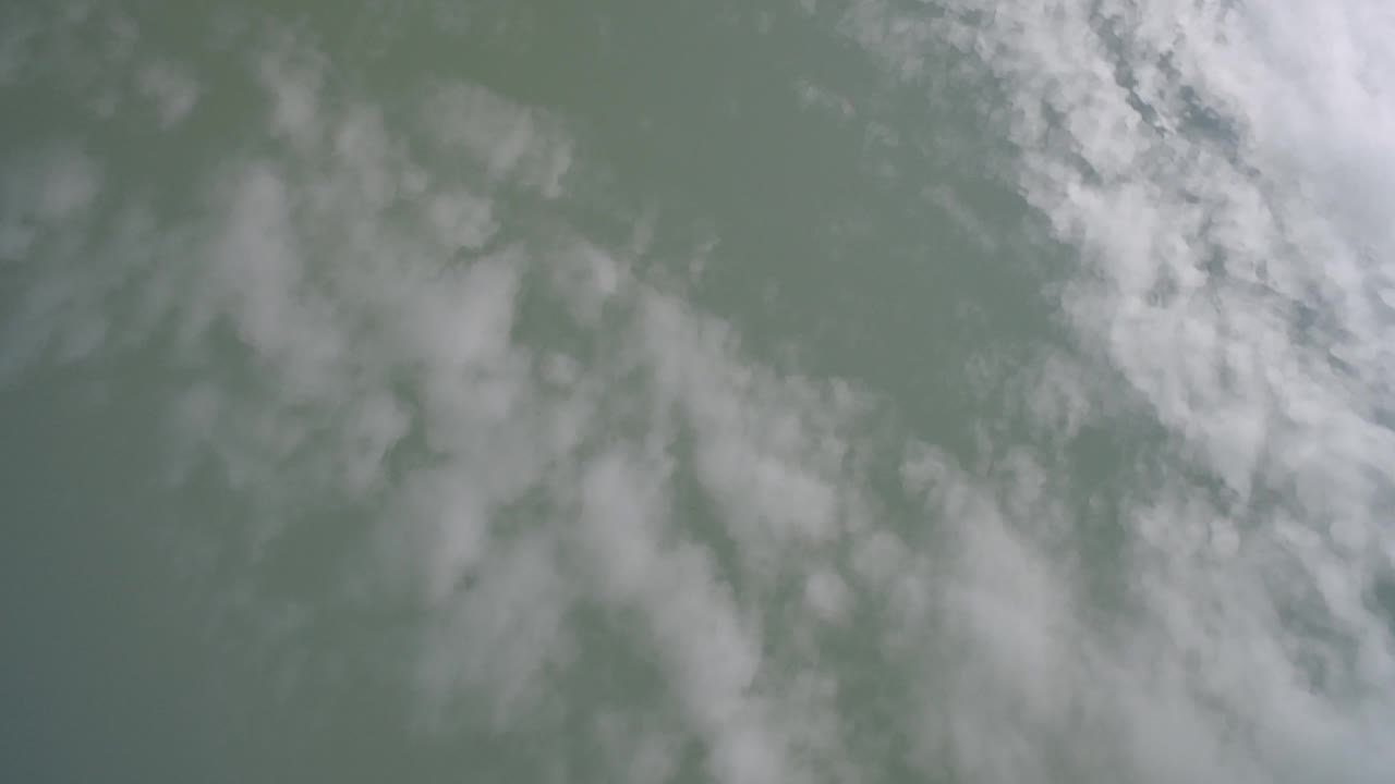 Cloud streaks crossing a flat gray-green sky