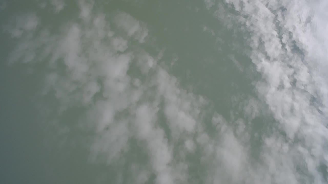 Cloud reflection crossing a flat lake surface