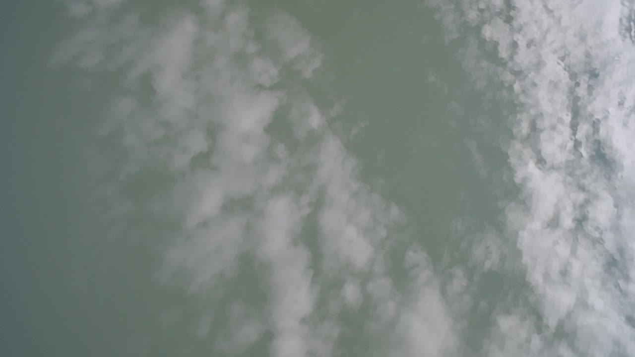 Soft white cloud forms over a muted green-gray field