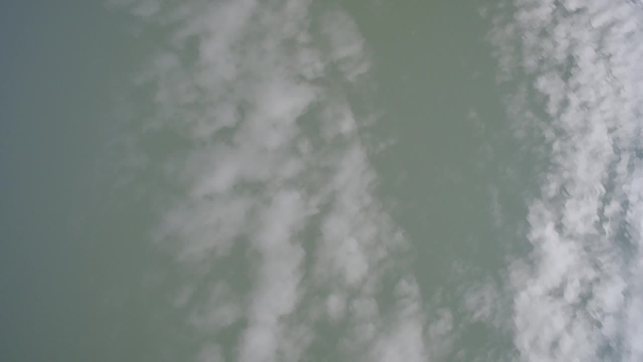 Green-tinted sky with soft white cloud streaks.