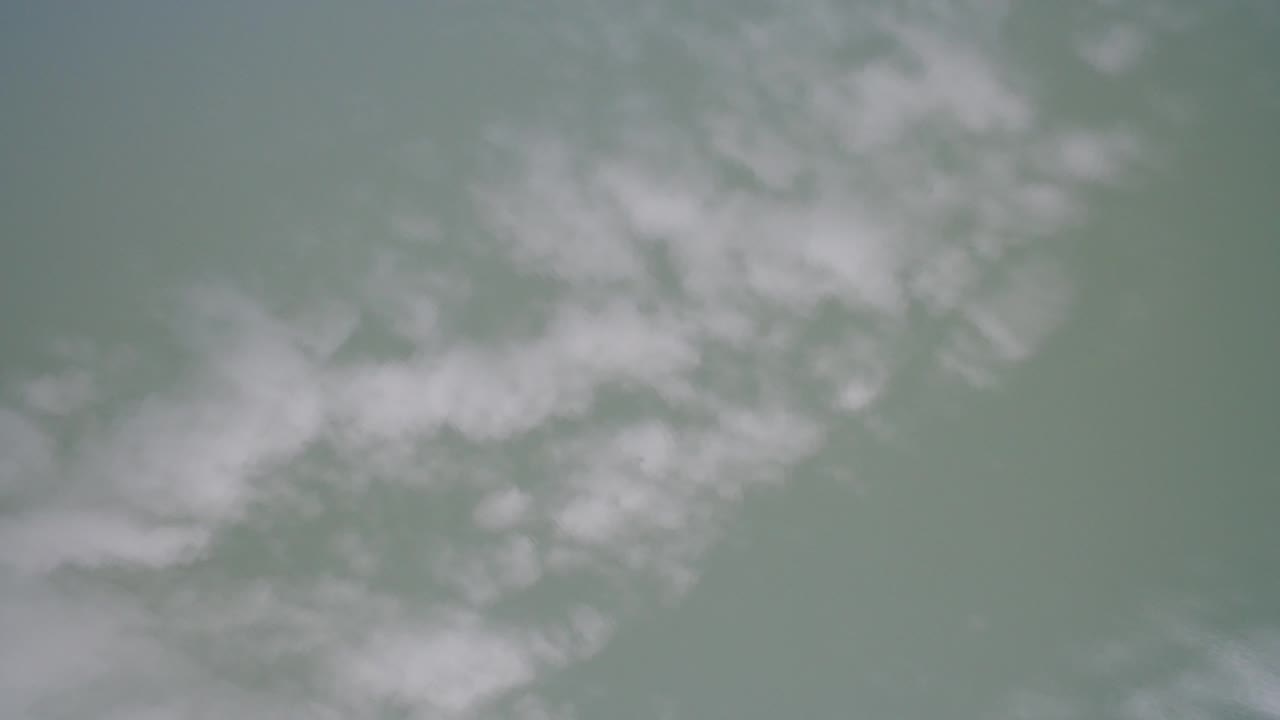 Soft green-gray water with pale misty patches.