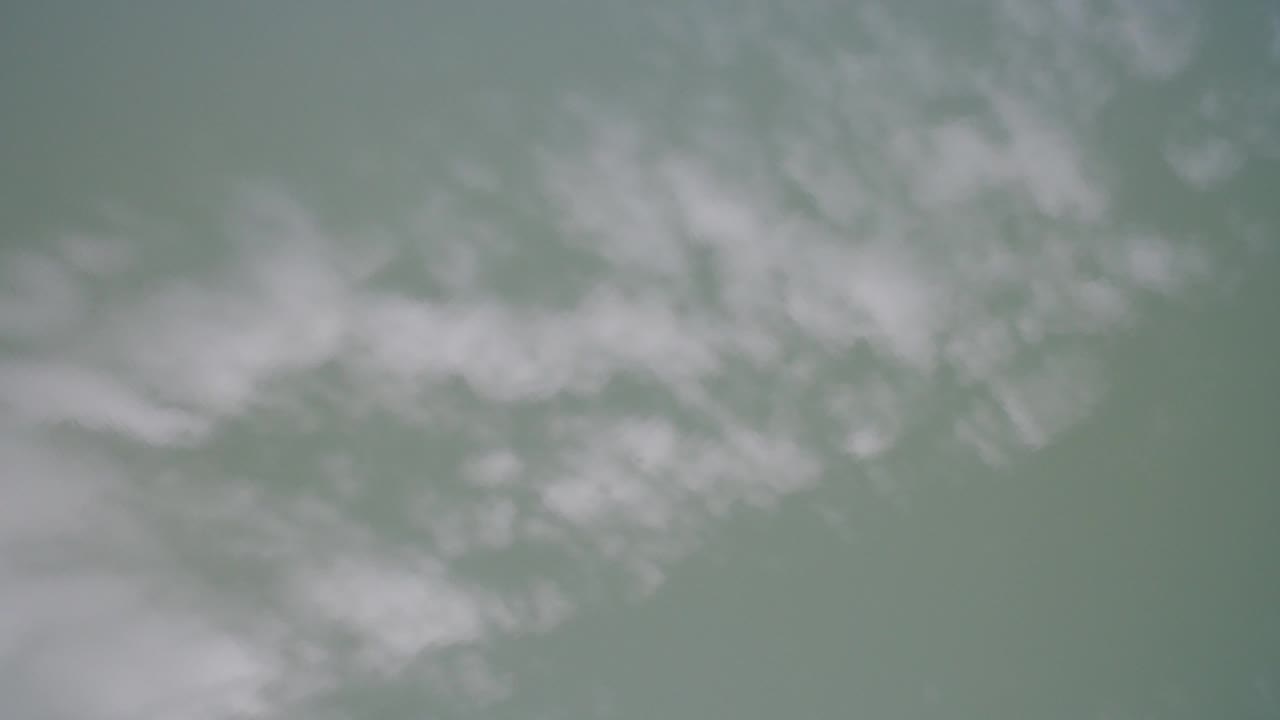 Soft green-blue water with pale white foamy texture.