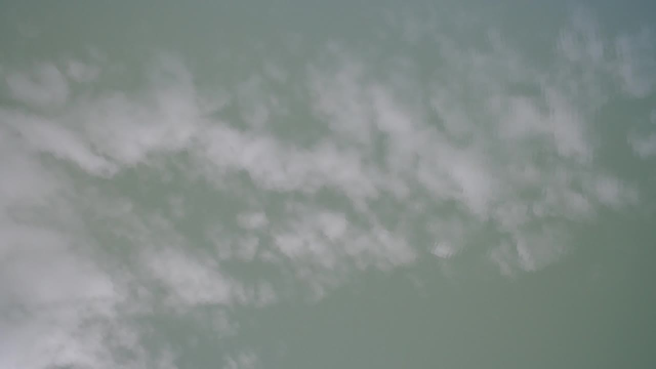 Pale cloud bands spread across a muted gray-green sky over Hidden Lake, Colorado, with no visible people, horizon, or structures.