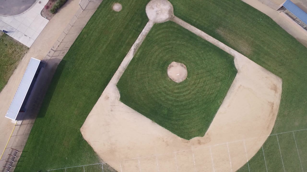 Overhead view of an empty baseball diamond and surrounding grass.