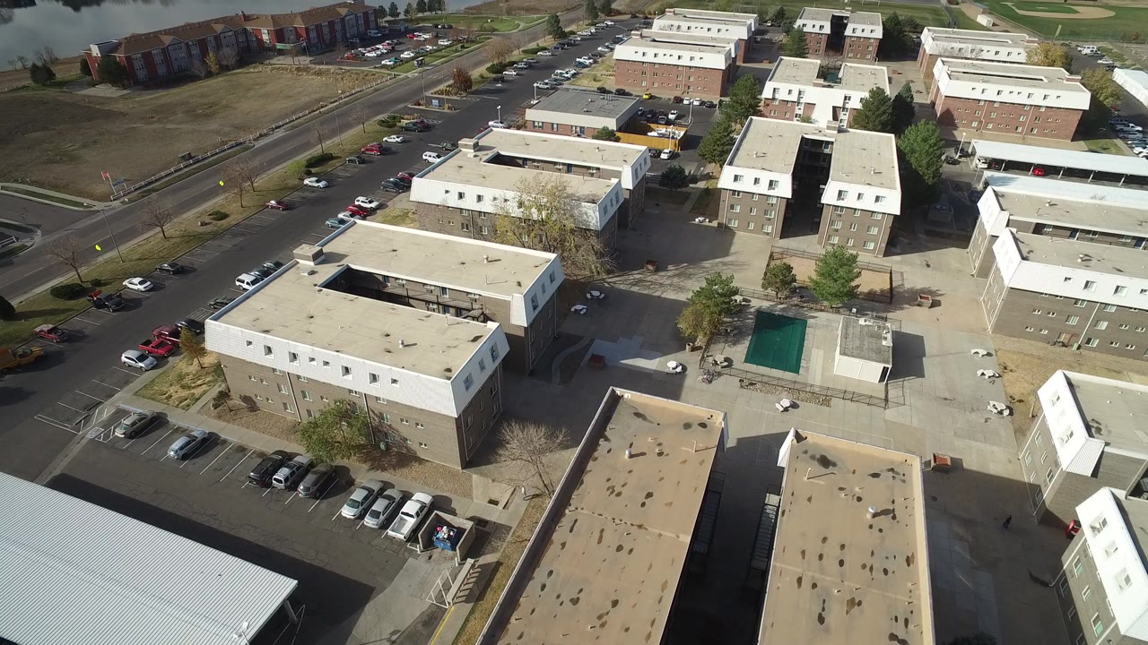Aerial frame in Hidden Lake, Colorado showing apartment-style blocks, a central paved area, curbside cars, and no visible people.