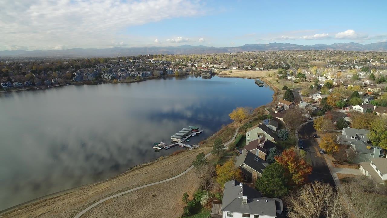Aerial view of a lake beside shoreline houses and docks.
