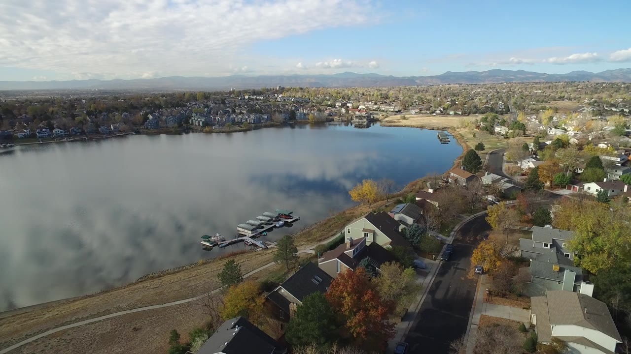 Aerial view of a lake beside residential streets and houses.