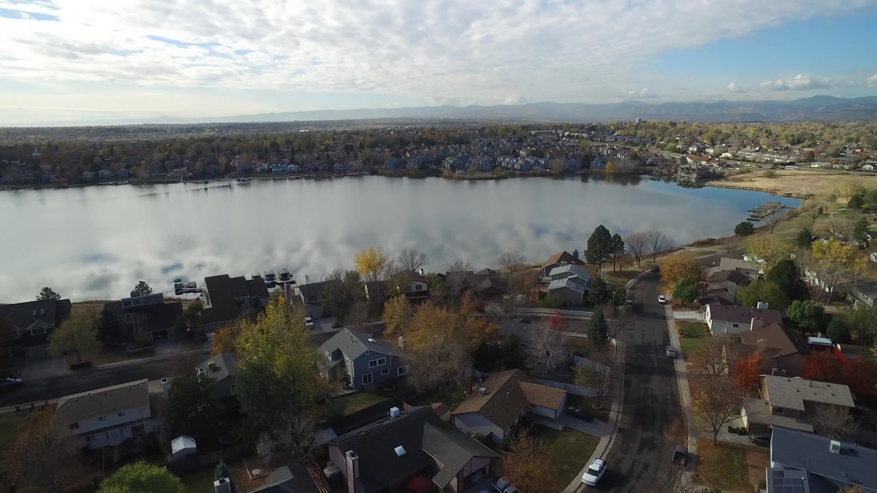 Rooftops, trees, and open water seen from a high angle.