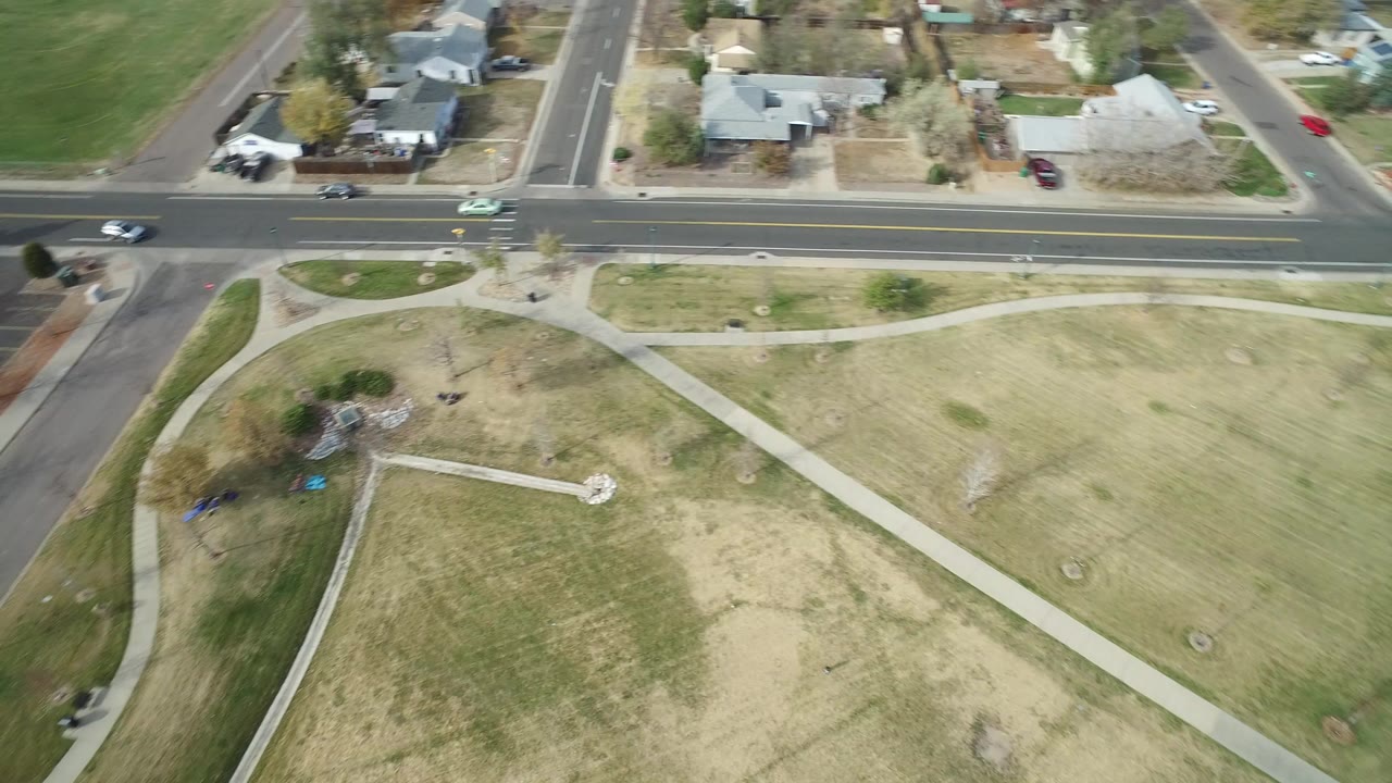 Overhead view of lawns, sidewalks, nearby streets, and a small playground area.