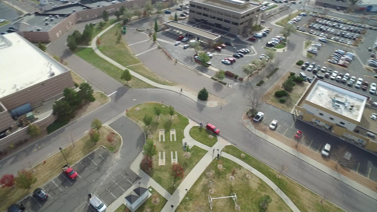Elevated view of roads, office buildings, parking lots, and grass paths.