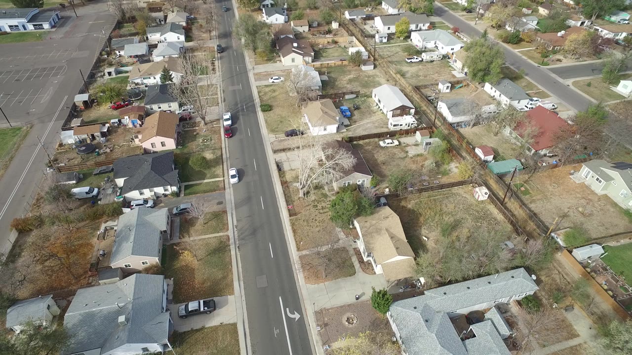 Aerial residential block with road and mixed lawns.