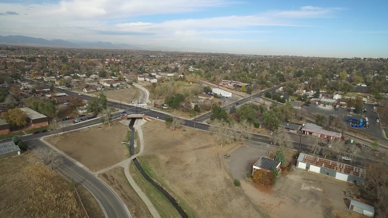 Aerial view of a bridge, open fields, roads, and suburban neighborhoods.