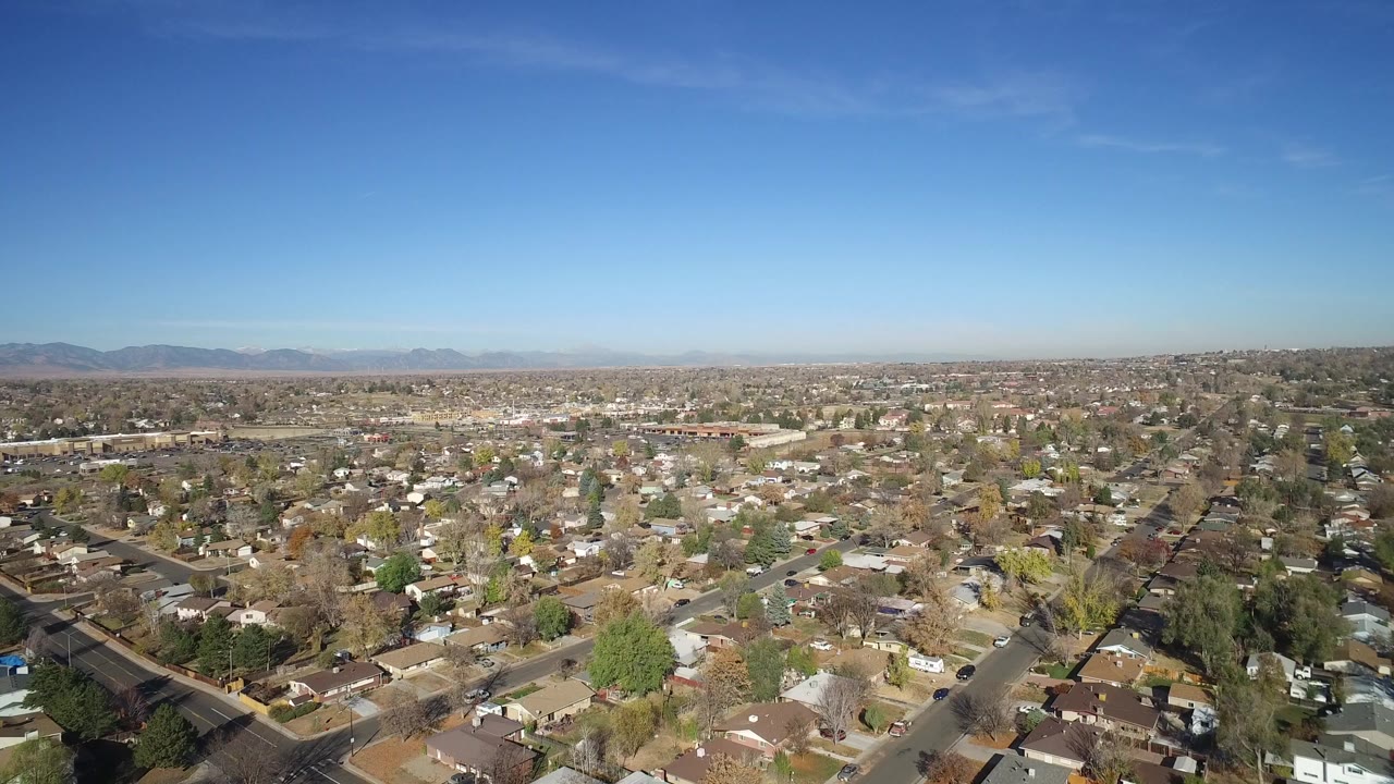 Aerial frame over Hidden Lake, Colorado showing dense rooftops, intersecting streets, scattered trees, a flat horizon, and no visible people.