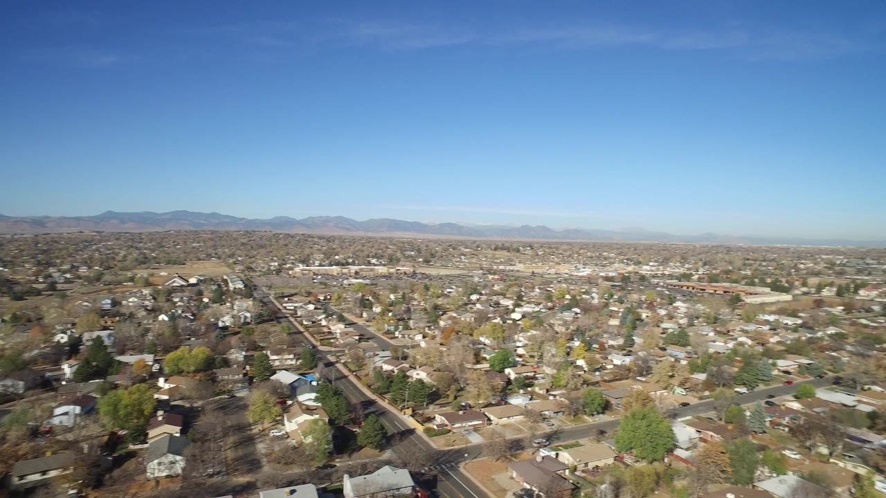 Wide aerial view of suburban homes under a blue sky