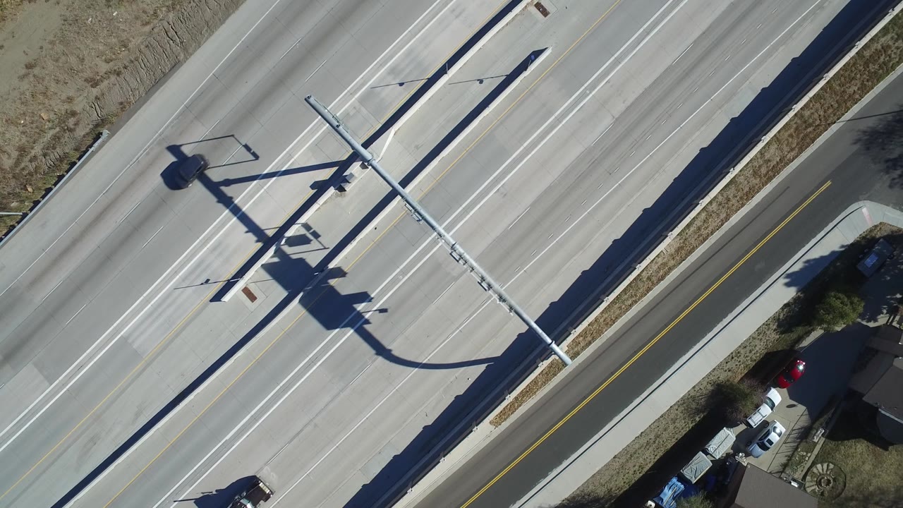 Top-down expressway lanes with a red vehicle entering the frame edge.