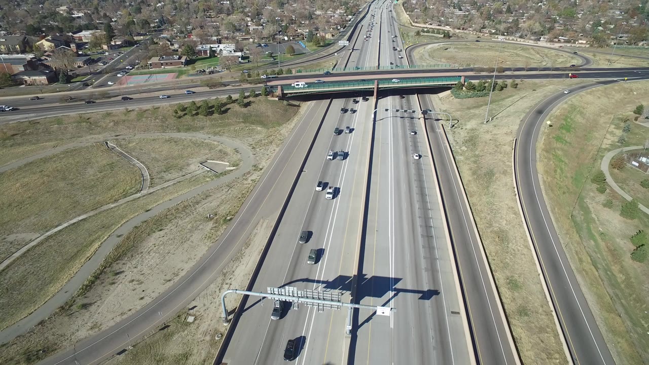 Aerial view of highway lanes, overpass, ramps, and cars.