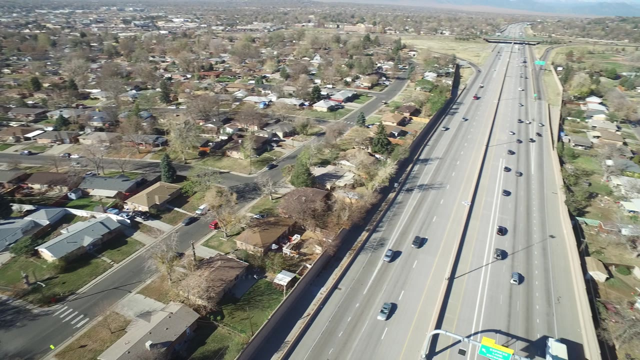 Aerial angle showing a residential street beside a larger road and highway edge.