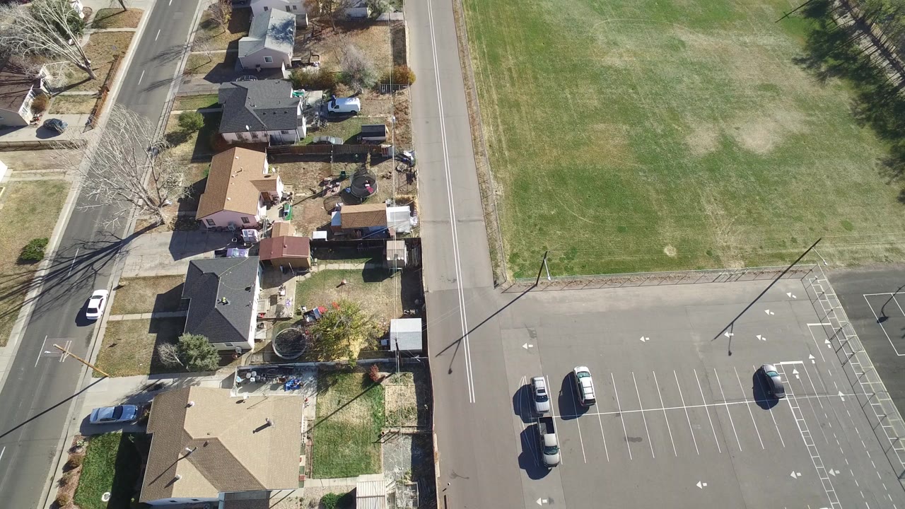 Overhead view of houses beside a road and grassy field