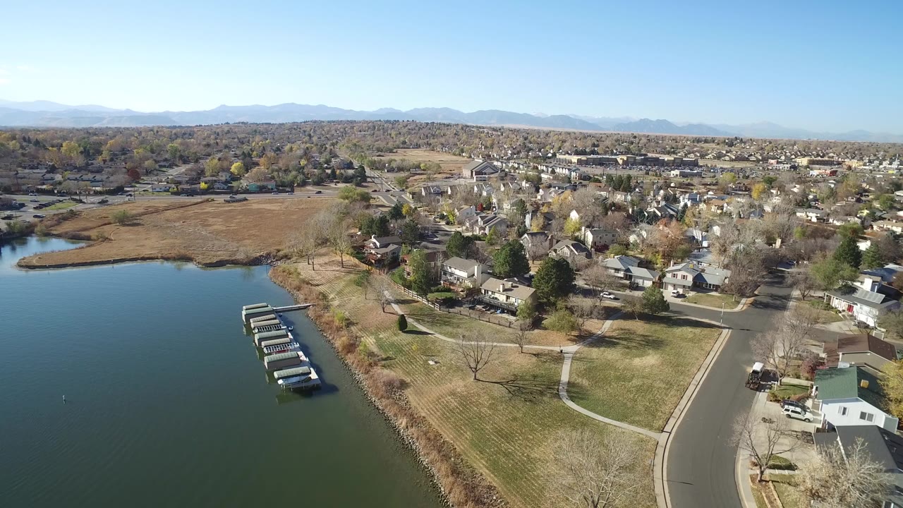 Aerial view of lake, docks, homes, roads, and distant mountains.