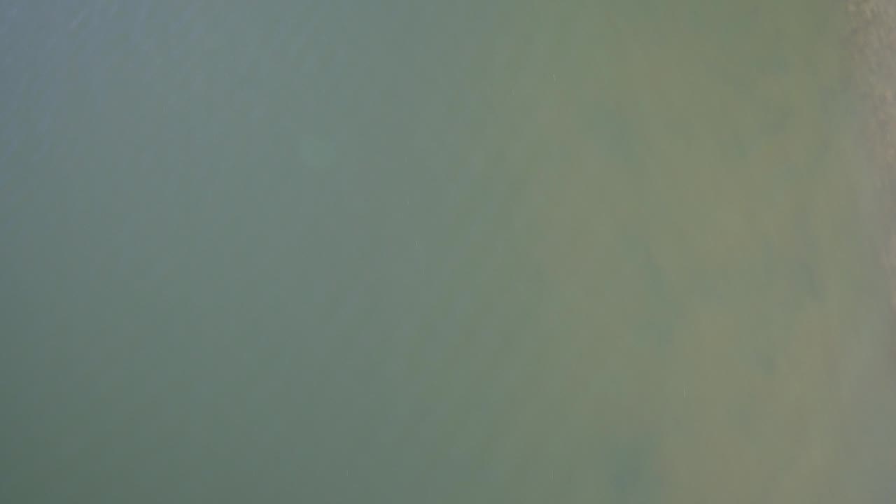 Overhead view of muted green lake water.