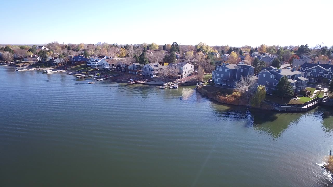 Aerial view of lakefront houses, docks, boats, and open water.