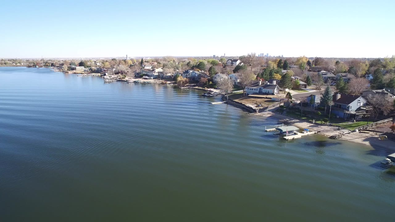 Aerial view of lake water beside a residential shoreline with docks.