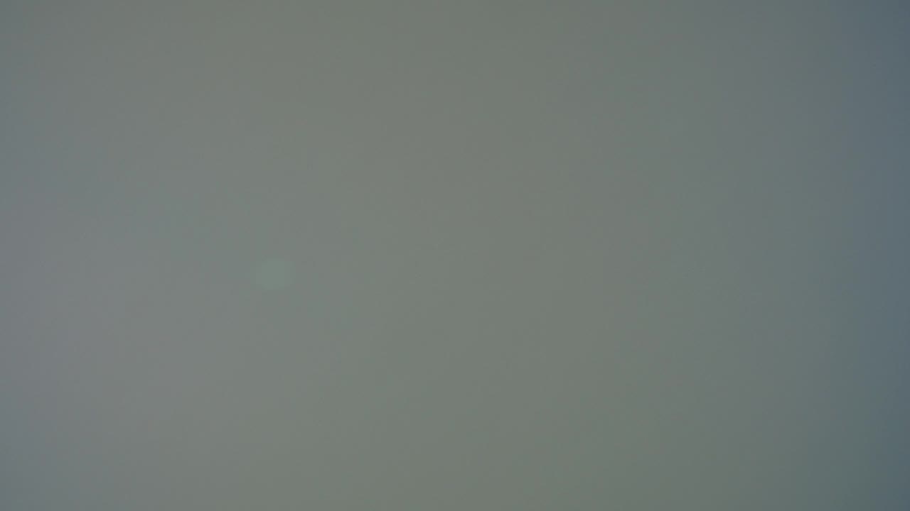 One second in, the frame remains a gray screen texture with slight mottling and no visible people, objects, or local features.